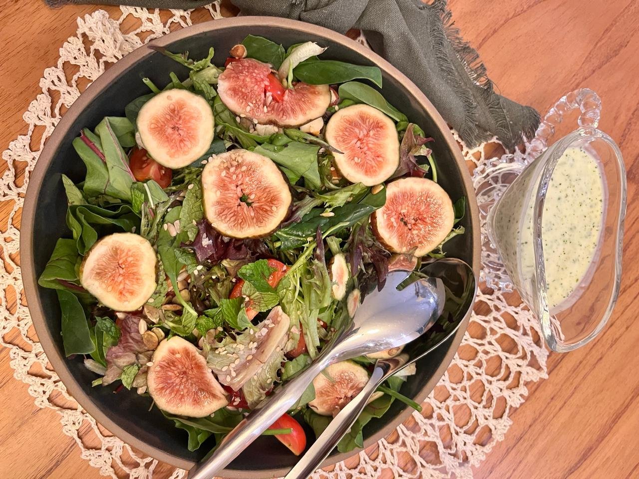 Salada com figos frescos acompanhada de molho de iogurte em molheira de vidro
