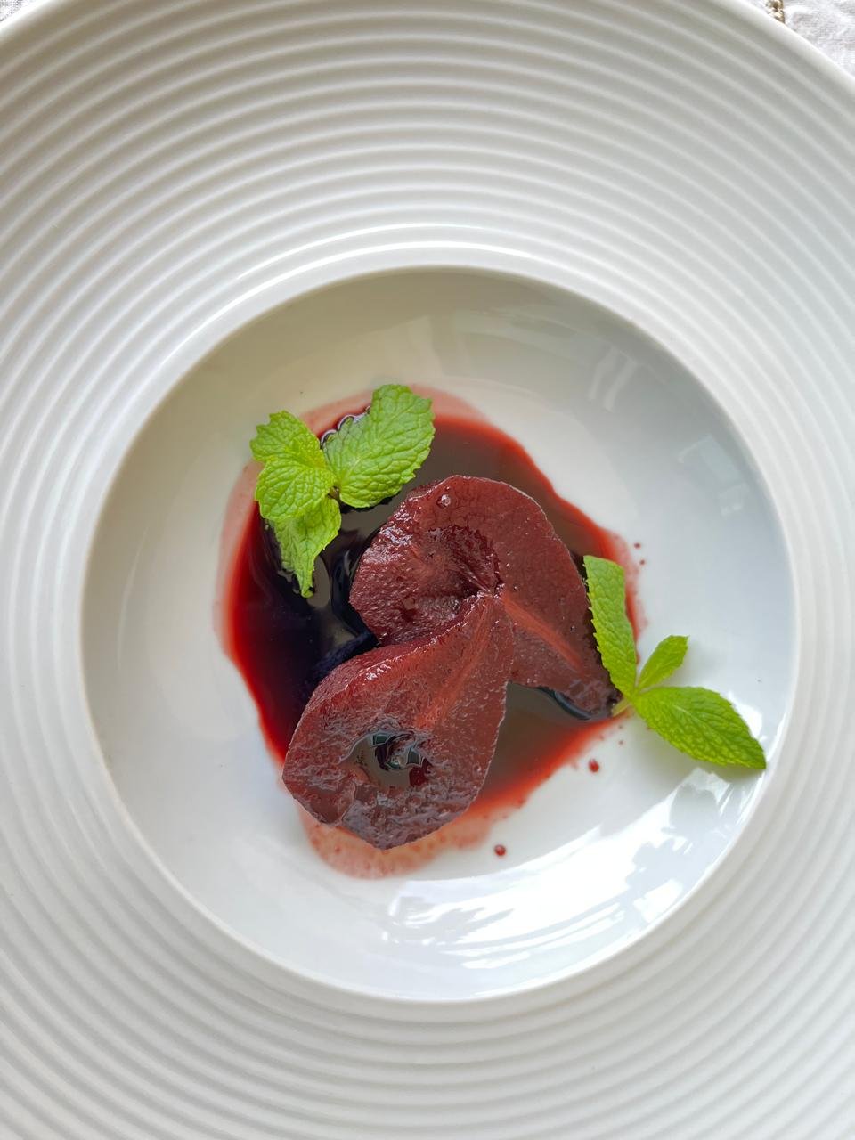 Pêra ao vinho servida em composição vertical